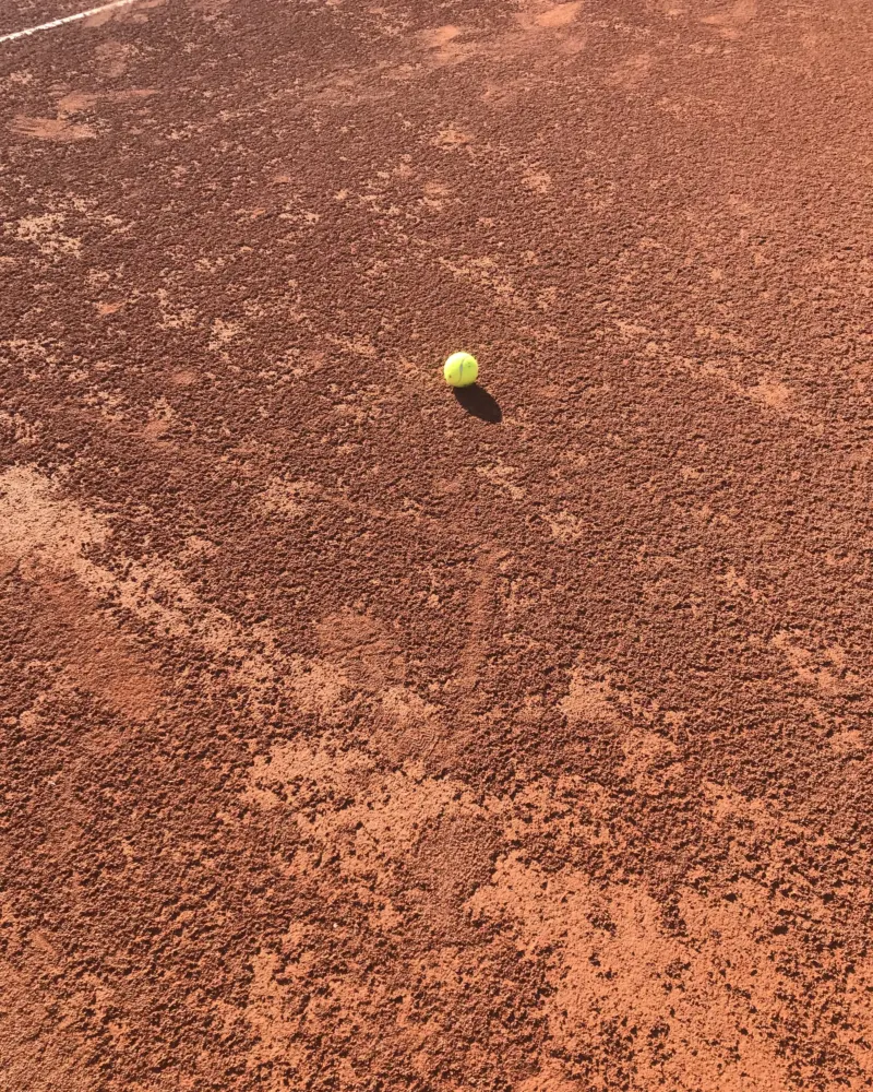Tennisball auf rotem Sandplatz
