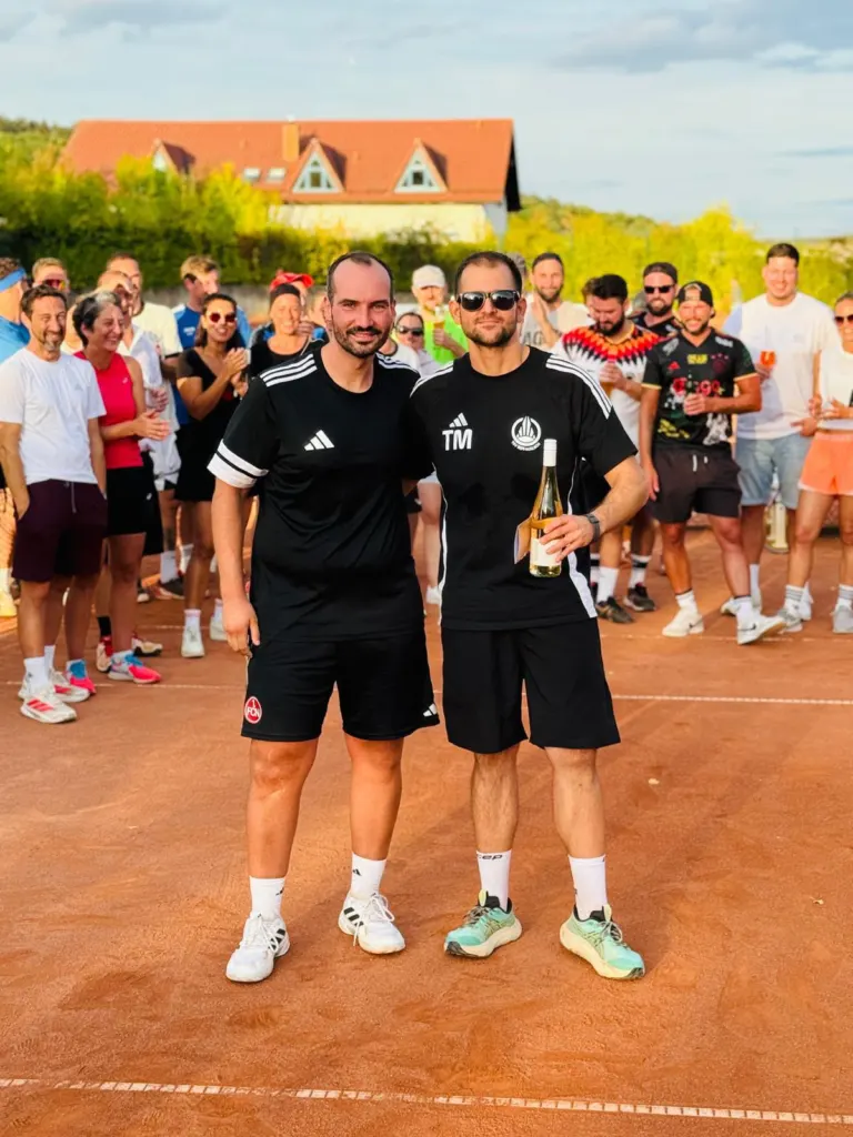 Zwei Spieler bei der Siegerehrung mit einer Flasche Wein